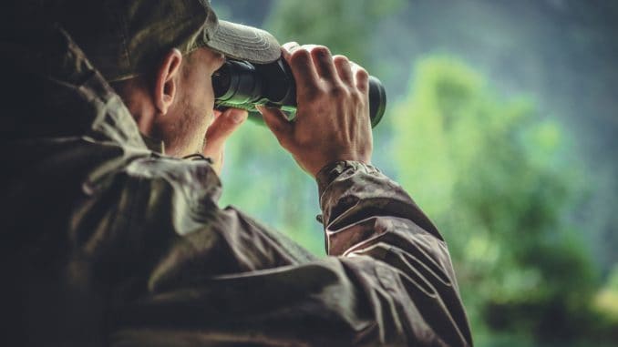 fernglas-ratgeber-bestandskontrolle-mann-beobachtet-mit-fernglas-etwas-in-der-natur